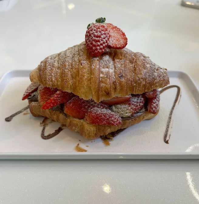 Croissant com morangos servido na confeitaria